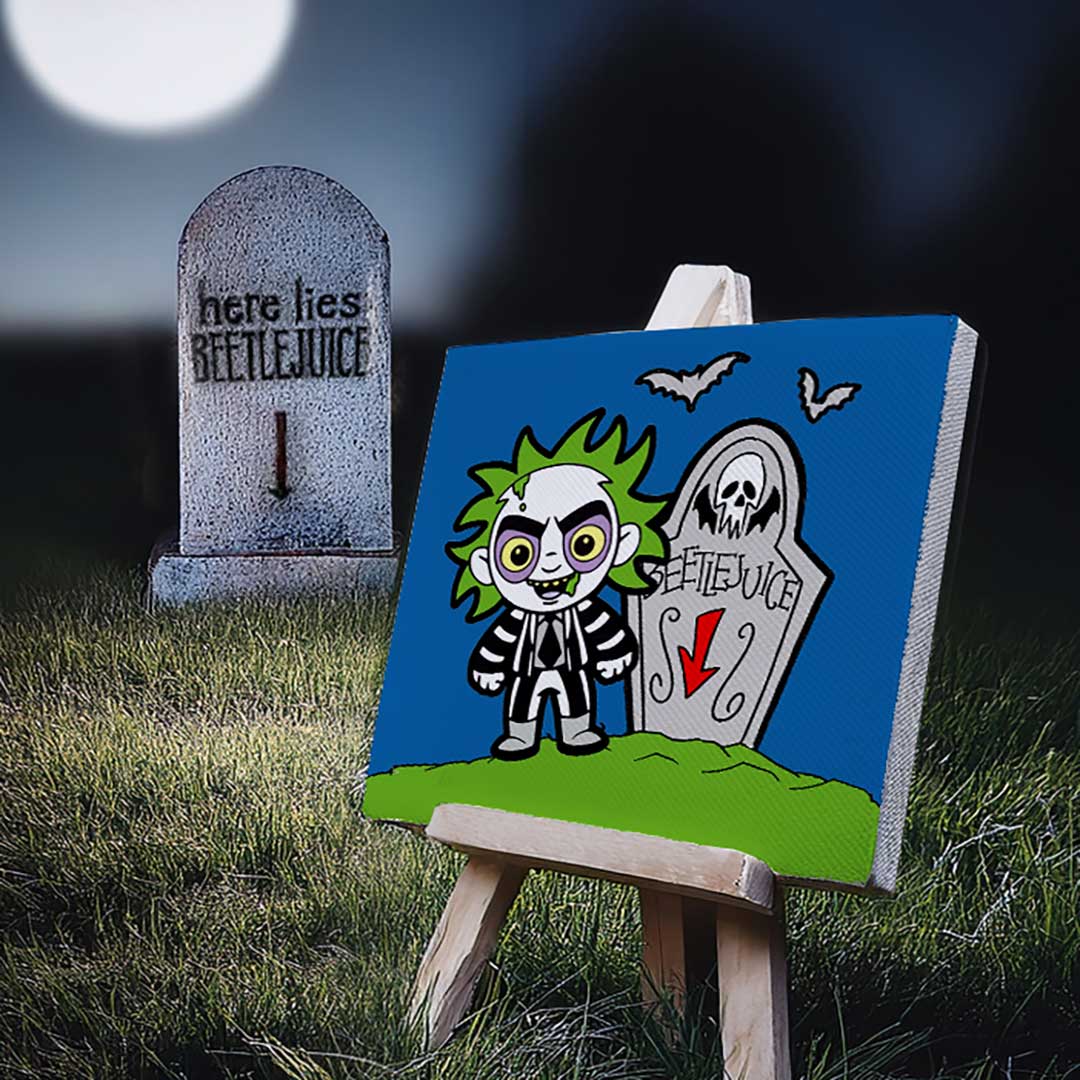 Finished pre-sketched Beetlejuice painting kit in front of a tombstone with 'Beetlejuice' text, set against a graveyard backdrop.