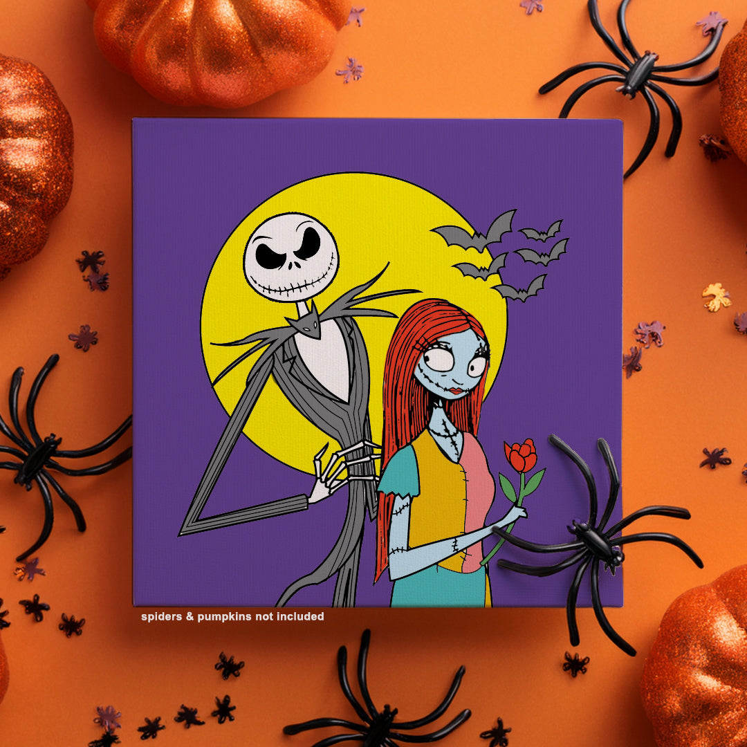 Painting kit of Jack Skellington and Sally on a purple background with a yellow moon and bats flying in the night laying on a table with Halloween decorations