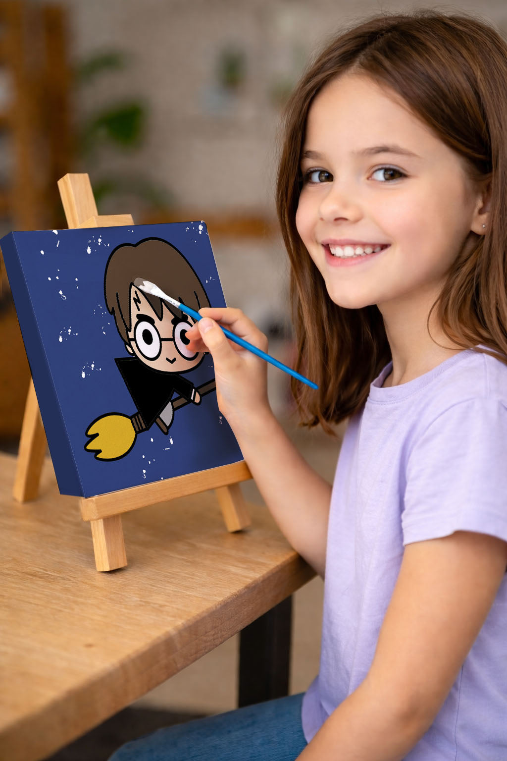 Child painting a cartoon character on a small canvas with an easel.